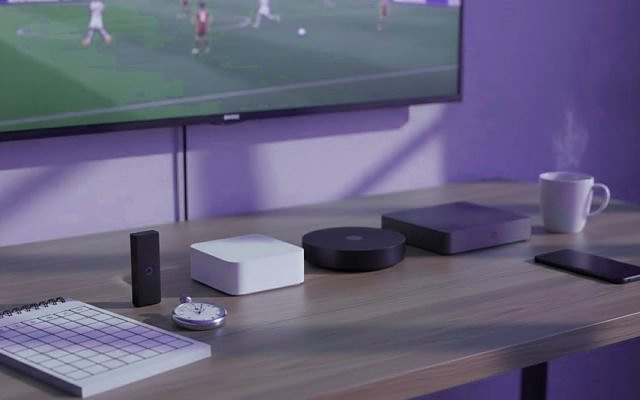 Cover for “Best IPTV service? Eight questions to ask any provider before you pay”: a streaming stick, small streaming boxes, a notepad and a coffee mug on a TV console while a football match plays